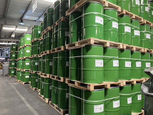 Lagerhalle mit gestapelten grünen Fässern auf Paletten